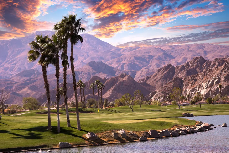 Golf course with palm trees and mountains in background in Palm Springs, California